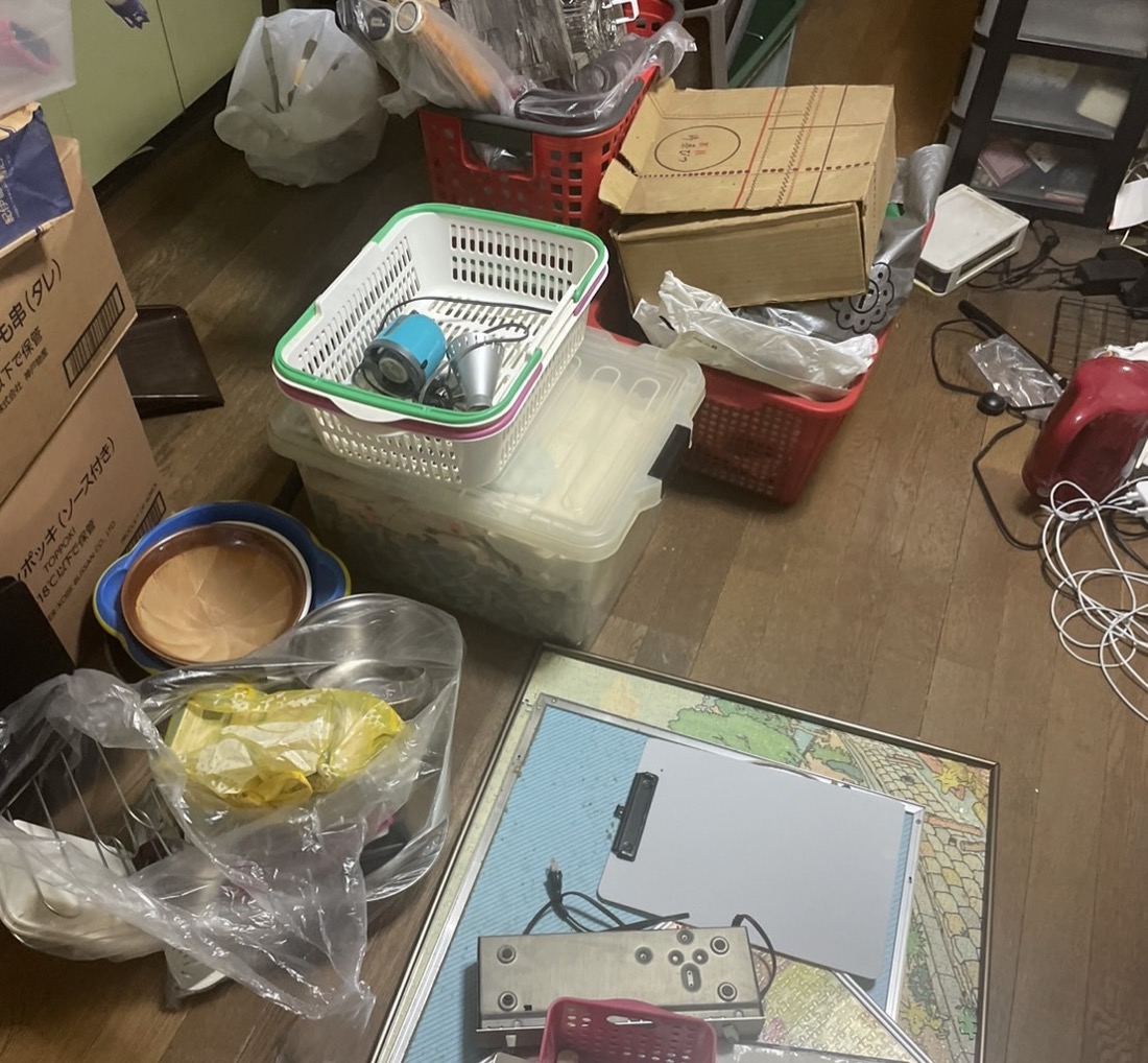 緑区十日市場町での回収前｜鍋やざる、収納ケースや段ボールが床いっぱいに広がった台所